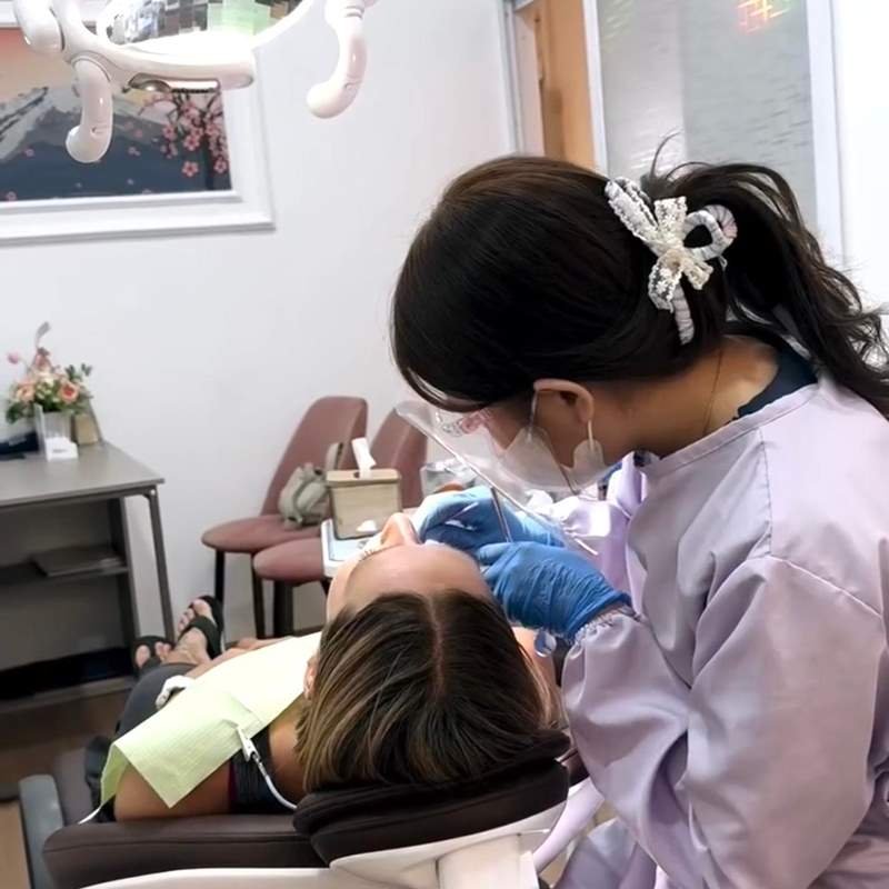 A Krystal Dental dentist examining an international patient
