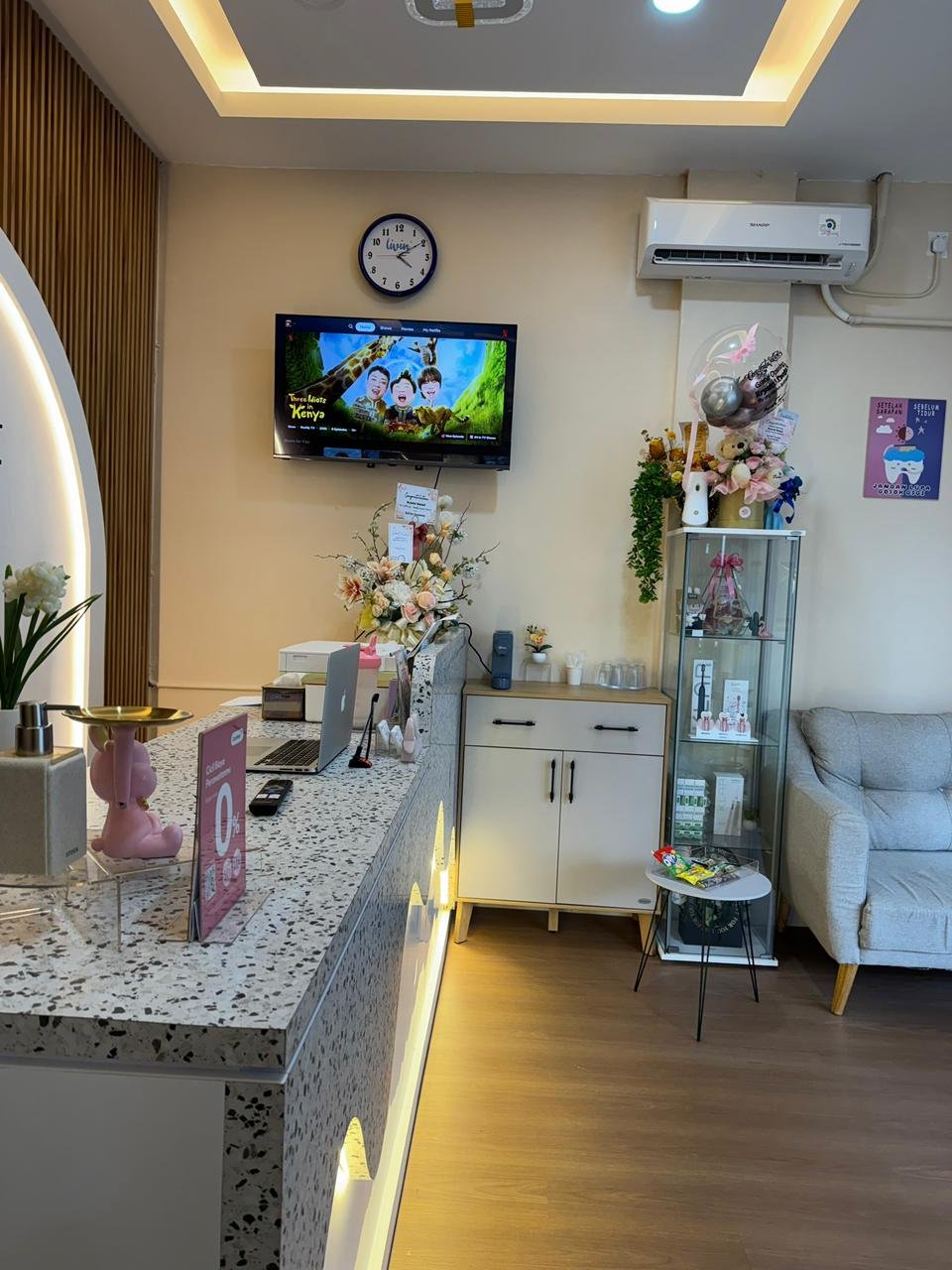 Area resepsionis Krystal Dental dengan meja terazzo dan pencahayaan hangat